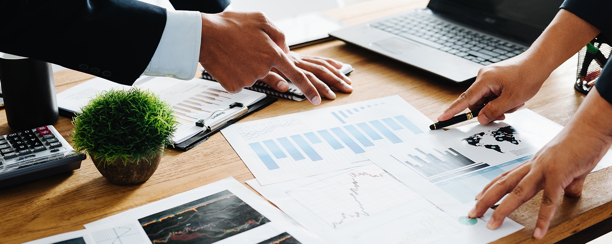 Professionals pointing at charts on table